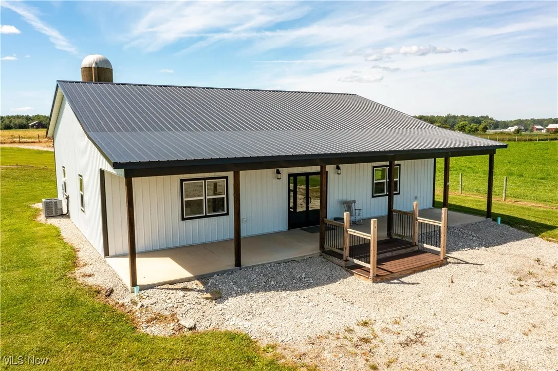 Back of property featuring a metal roof and a yard