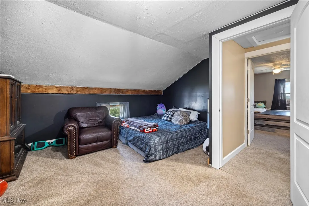 Carpeted bedroom with a textured ceiling and lofted ceiling