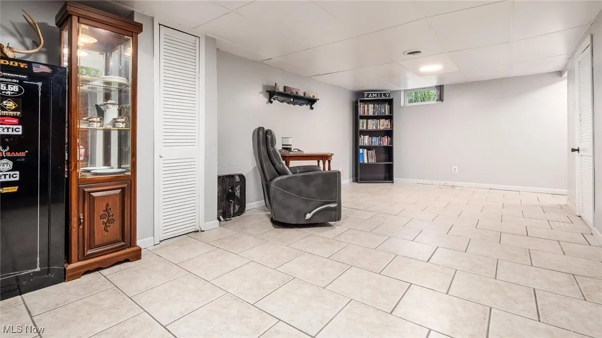 Sitting room with light tile patterned floors and a drop ceiling
