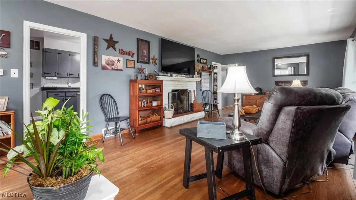 Living room with wood finished floors and a brick fireplace