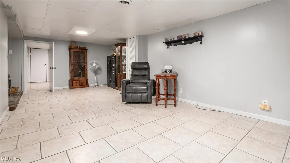 Sitting room featuring light tile patterned floors and a drop ceiling