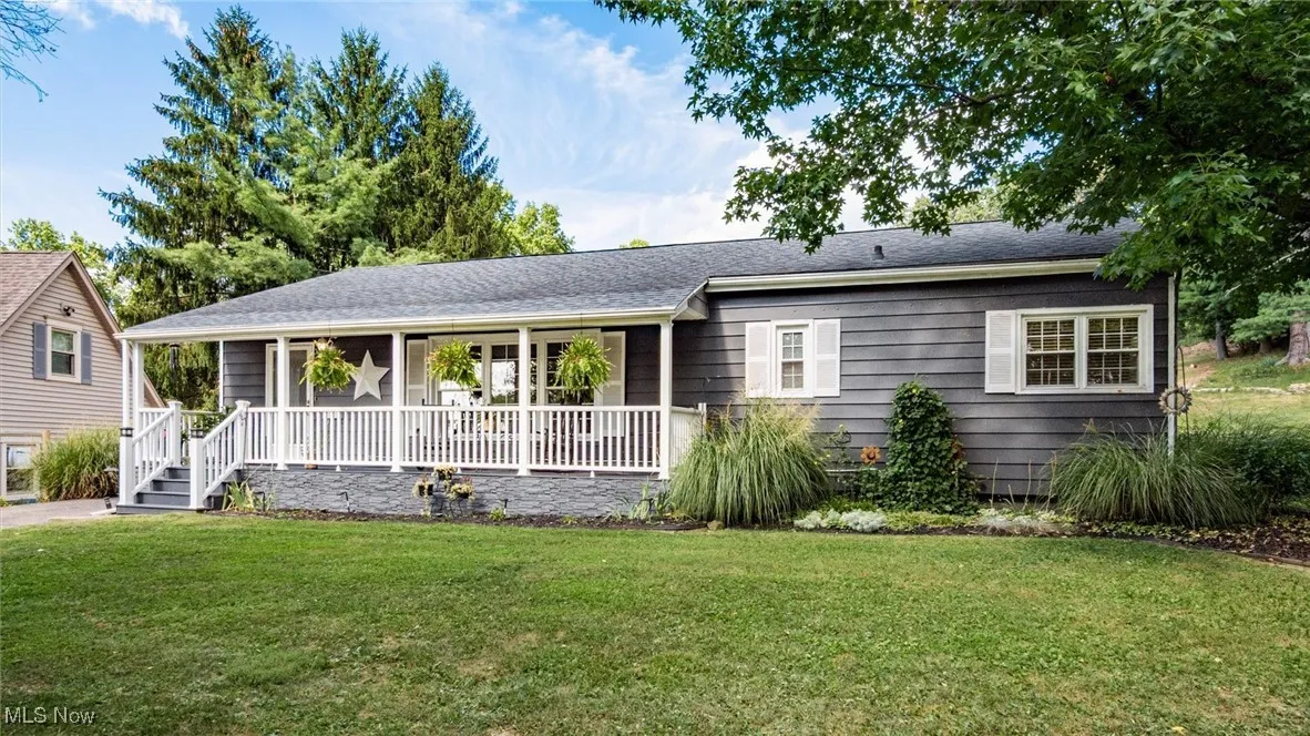 View of front of home featuring a front yard and a shingled roof