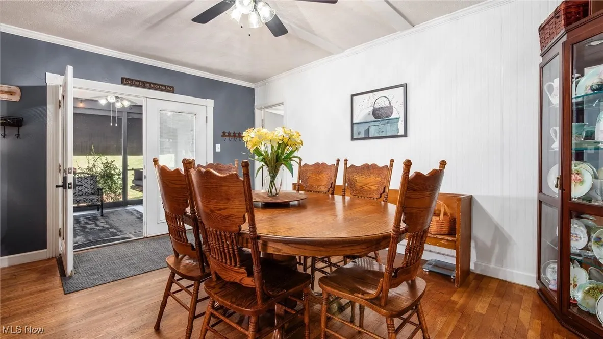 Dining room with wood finished floors and crown molding