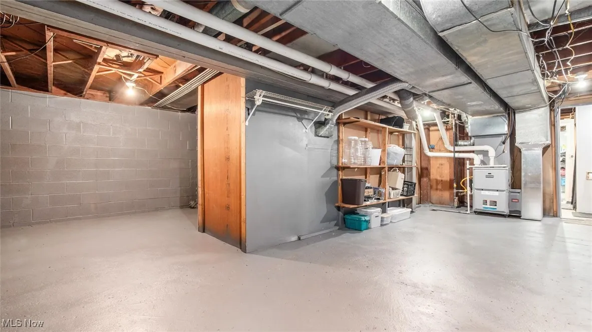 Unfinished below grade area featuring heating unit