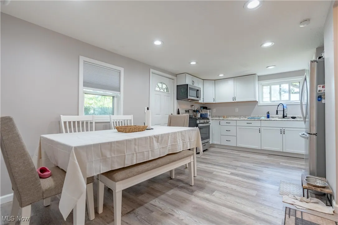 Dining room with healthy amount of natural light, recessed lighting, and light wood-style flooring