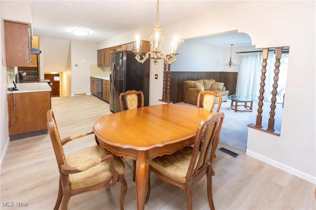 Dining room with light wood finished floors and a chandelier