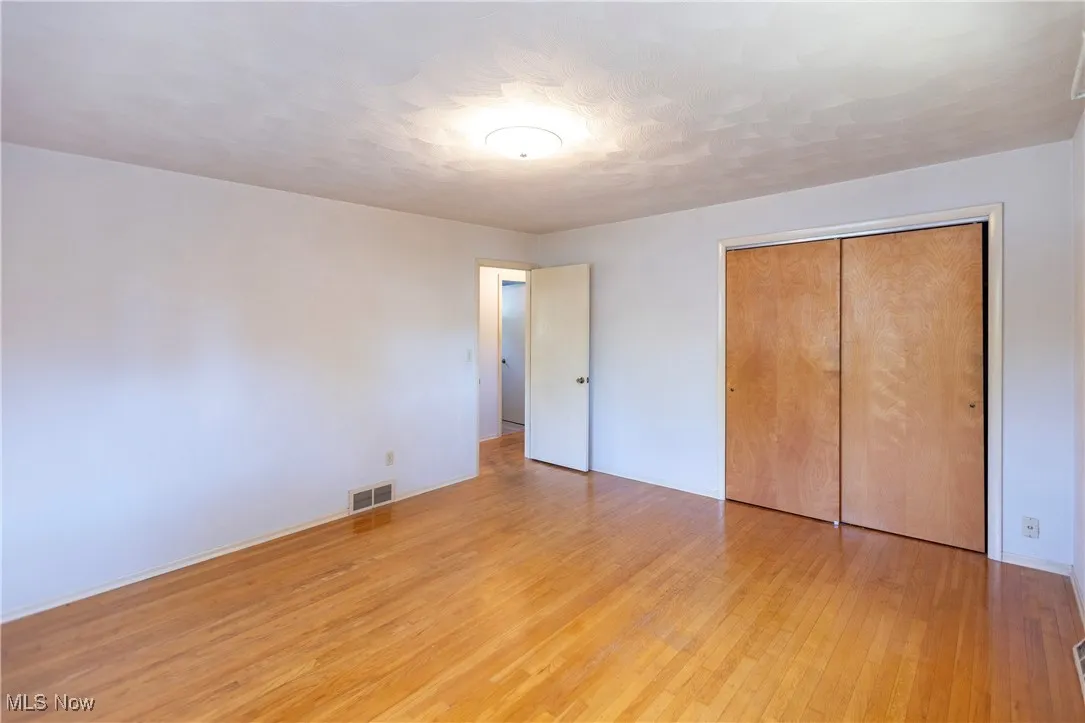 Unfurnished bedroom featuring light wood finished floors, a closet, and a textured ceiling