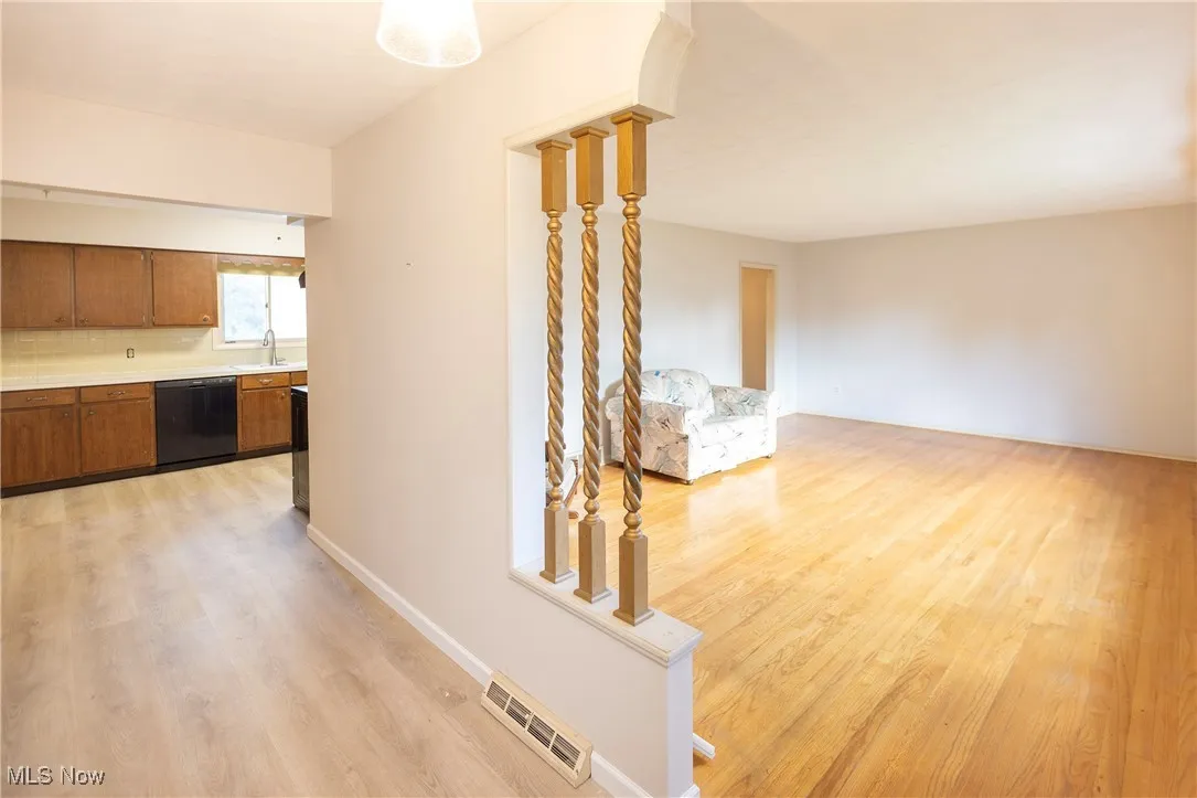 Hallway with light wood-type flooring and baseboards