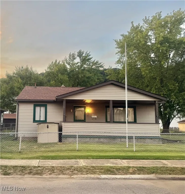View of front of home with a porch and a fenced front yard