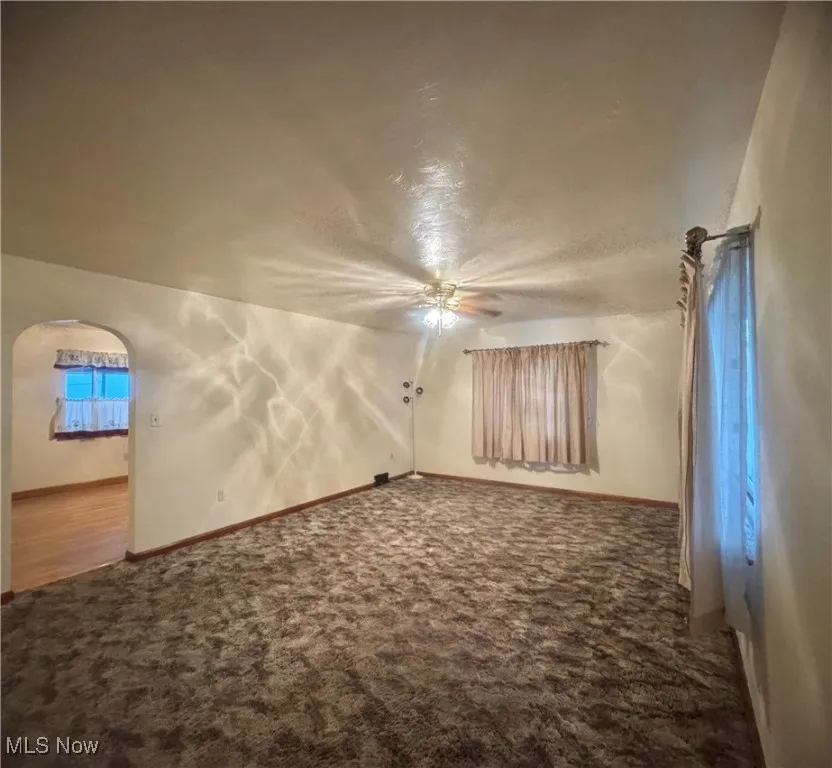 Additional living space with arched walkways and carpet