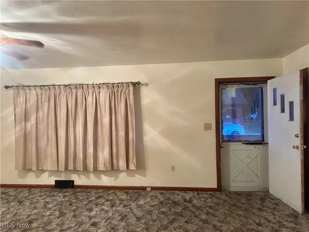 Carpeted foyer featuring baseboards