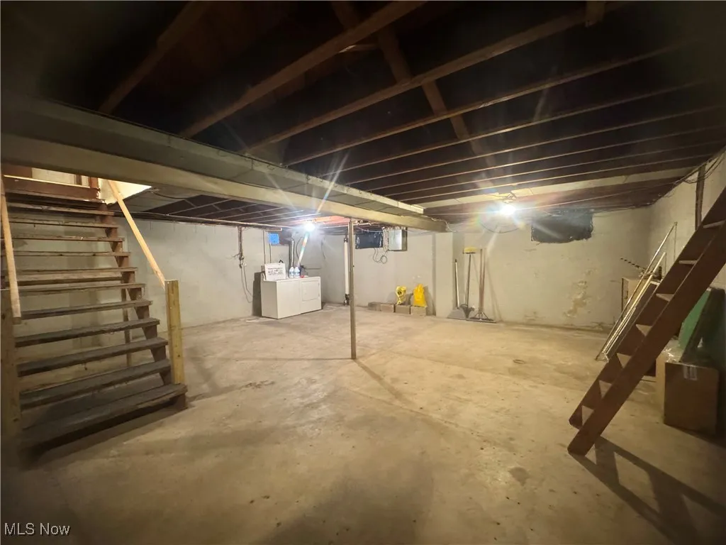 Unfinished basement with stairway and washer / clothes dryer