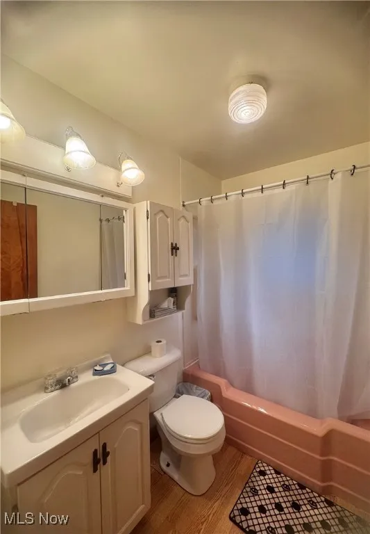 Full bathroom featuring shower / bath combo, vanity, and light wood-type flooring