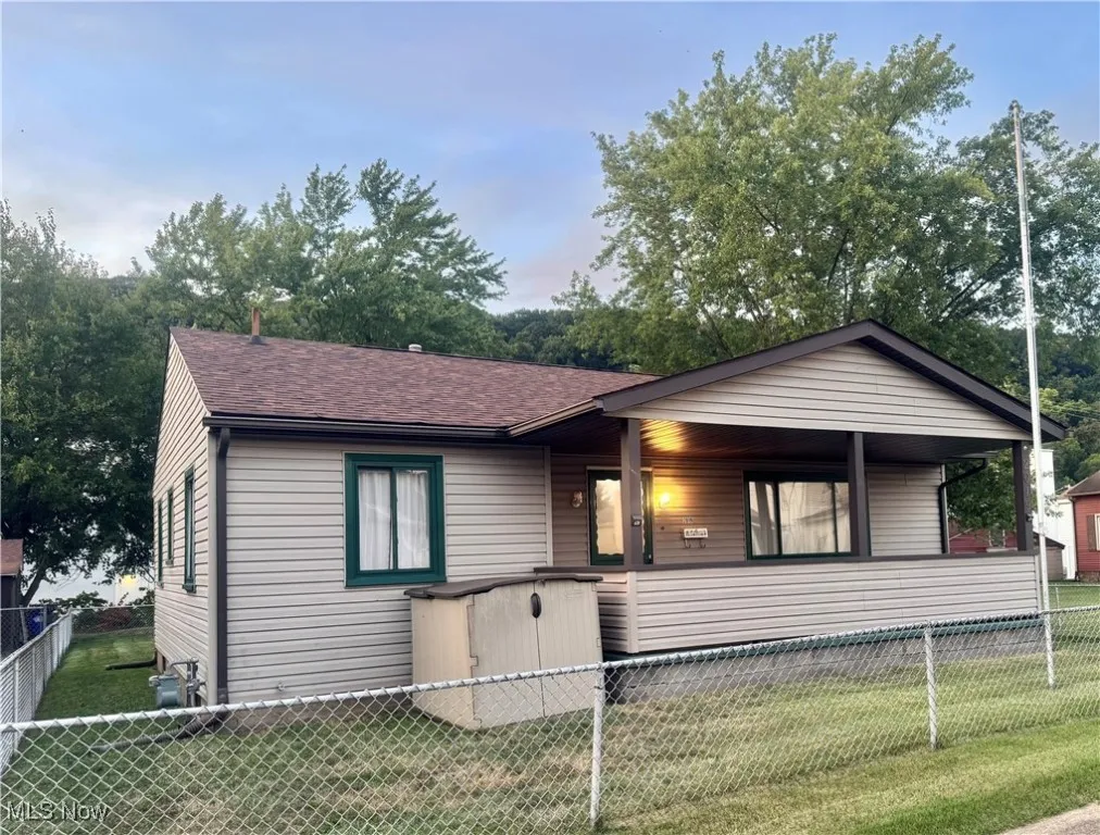 View of front of house with a fenced front yard and roof with shingles