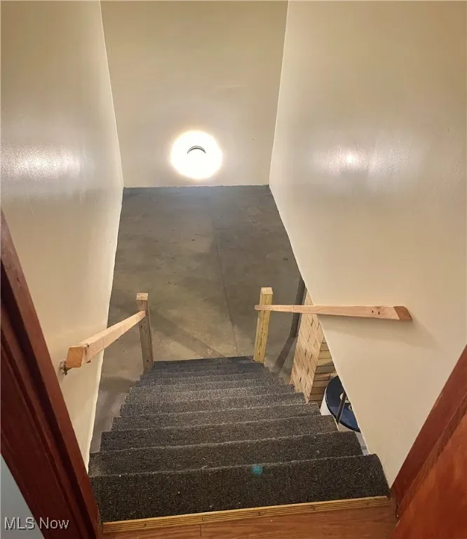 Staircase featuring concrete flooring