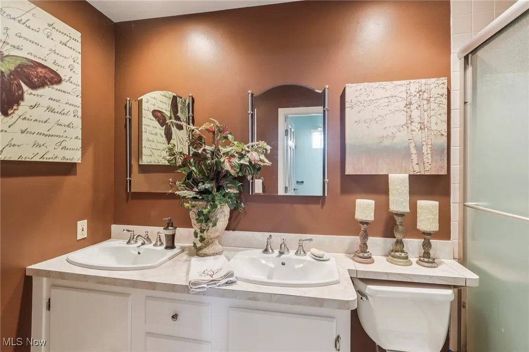Full bath featuring a shower stall and double vanity