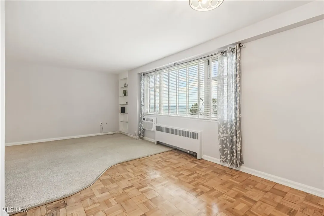 Spare room featuring radiator and baseboards