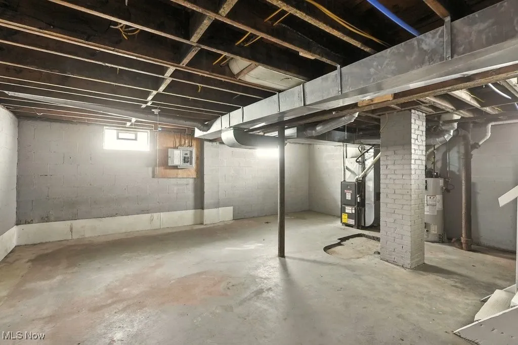 Basement with water heater, electric panel, and heating unit