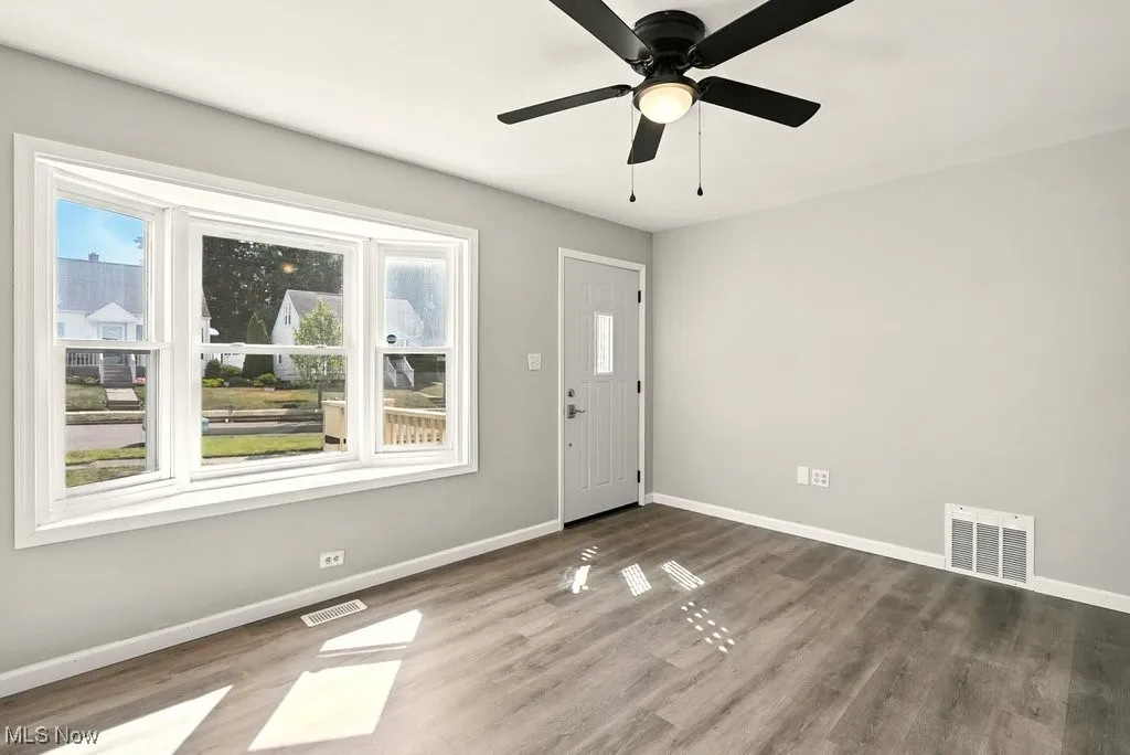 Living room featuring healthy amount of natural light, wood finished floors, and ceiling fan