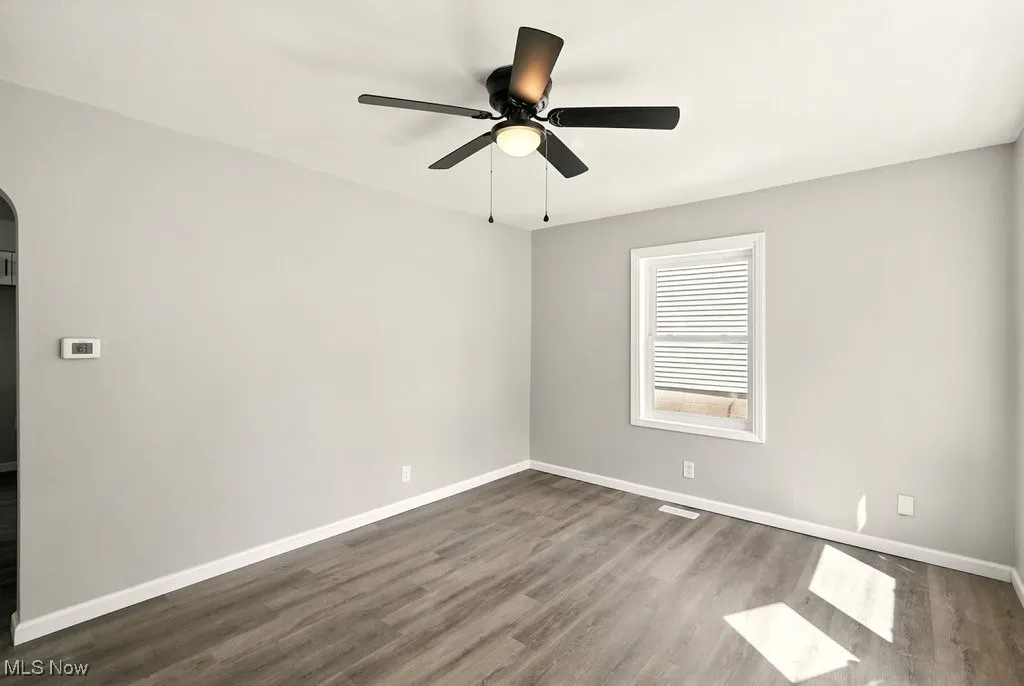 Living room featuring dark wood-style floors and ceiling fan
