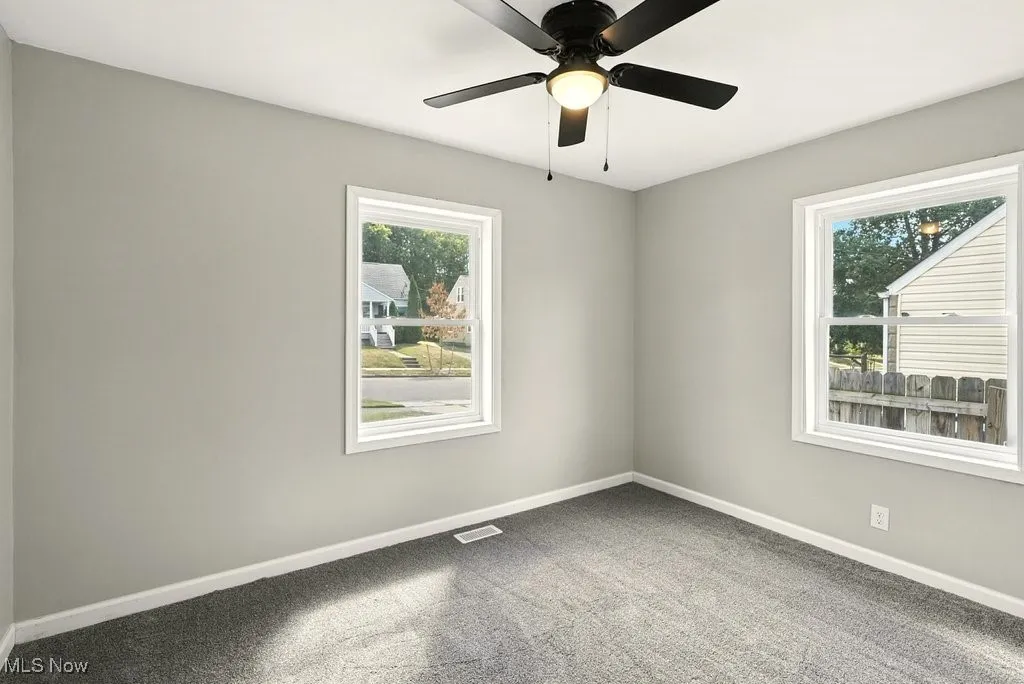 Carpeted bedroom with healthy amount of natural light and ceiling fan
