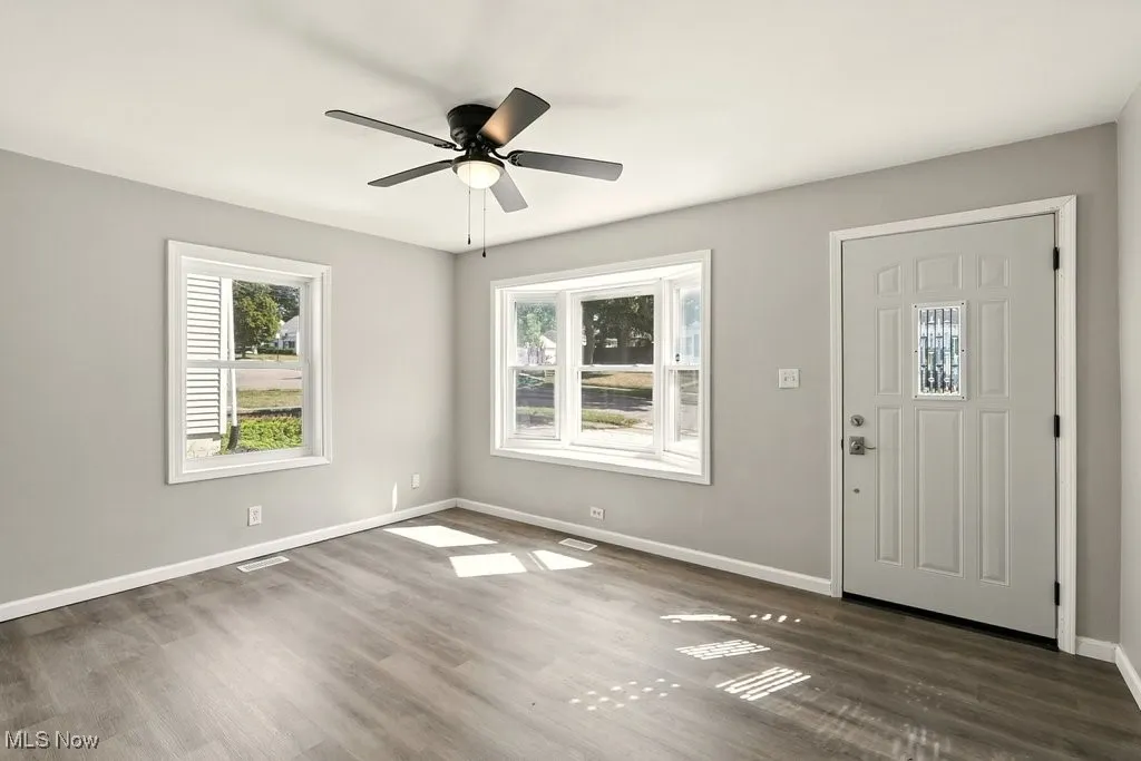 Living room featuring dark wood-type flooring and a ceiling fan
