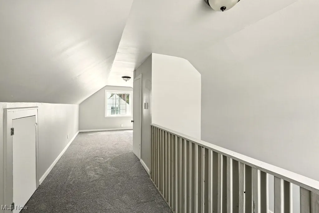 Hall with vaulted ceiling and carpet floors