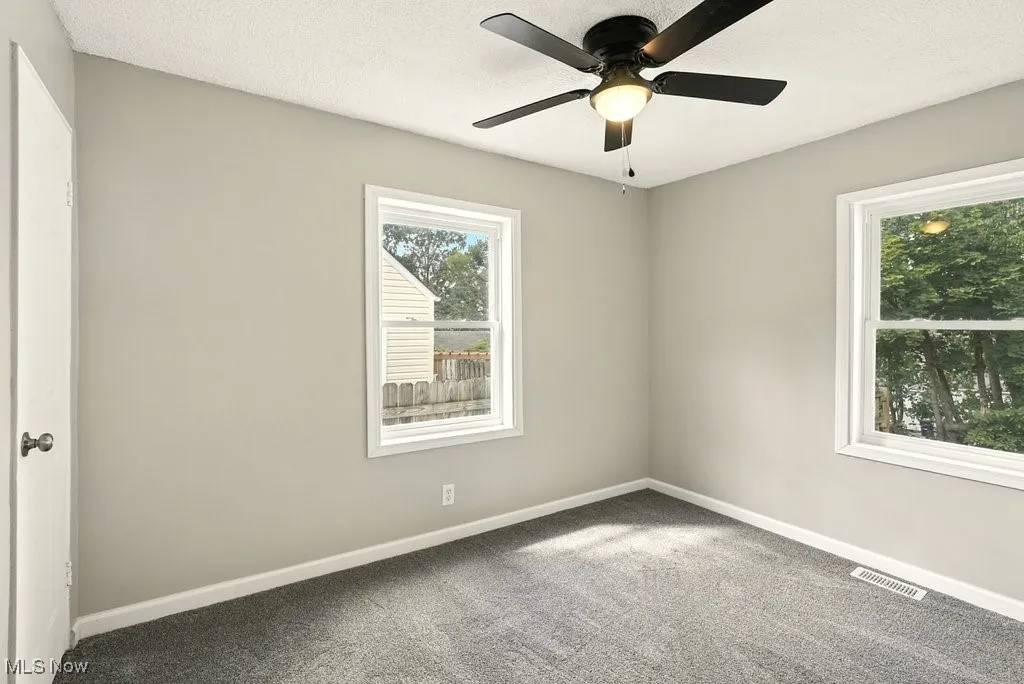 Bedroom with carpet flooring, a textured ceiling, and a ceiling fan
