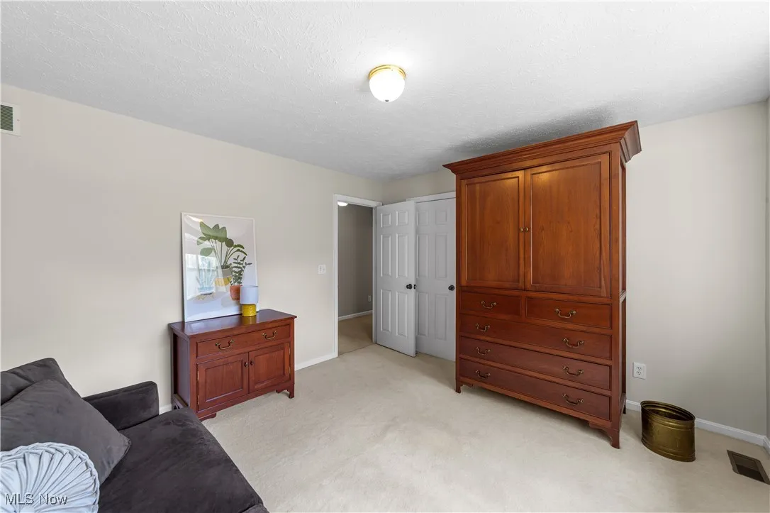 Sitting room with light carpet and a textured ceiling