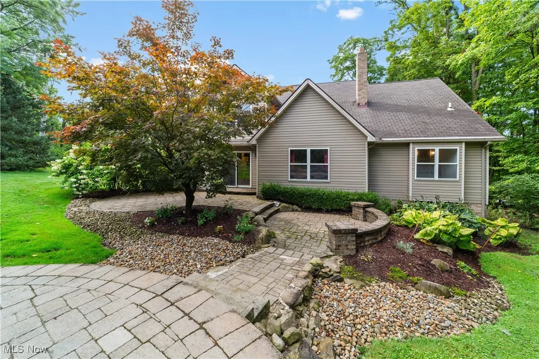 View of back property with a chimney and a front yard