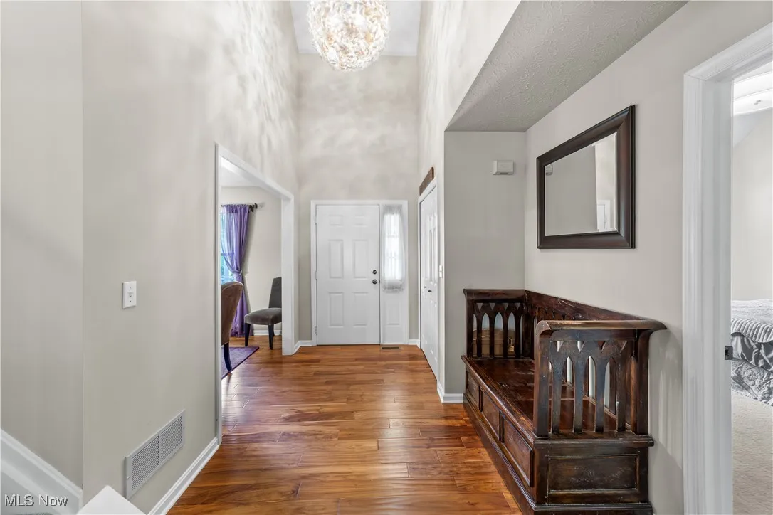 Entryway with a chandelier and dark wood-style floors