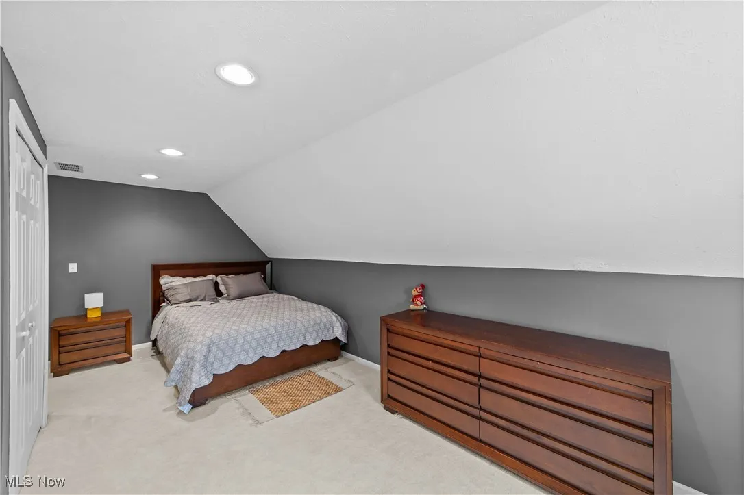 Carpeted bedroom with lofted ceiling, a closet, and recessed lighting
