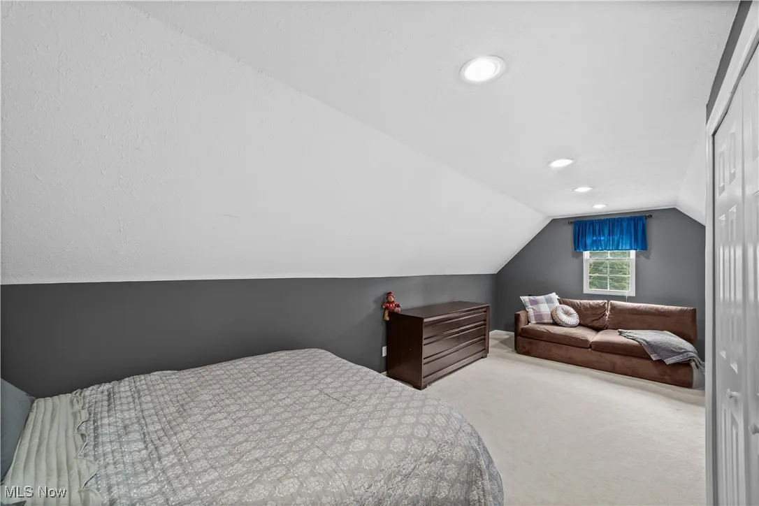 Bedroom featuring carpet, lofted ceiling, recessed lighting, and a closet
