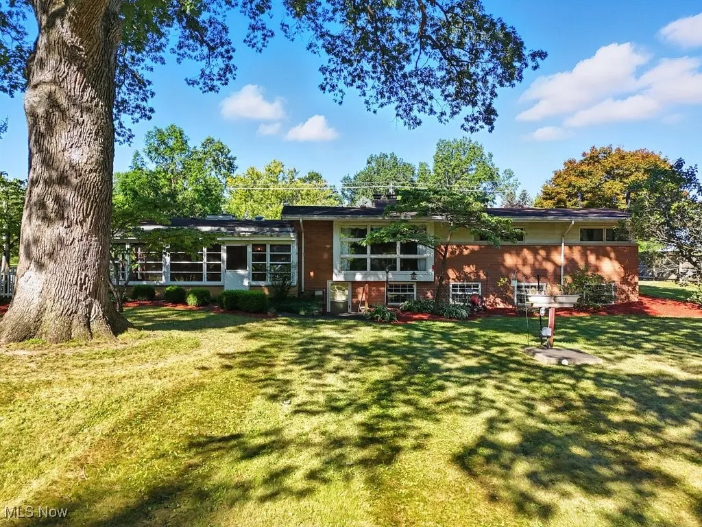 Rear view of property with a lawn