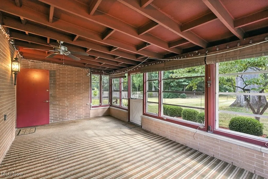 Unfurnished sunroom featuring a ceiling fan