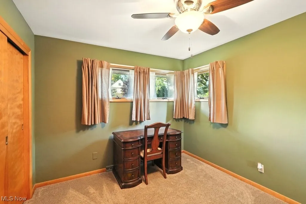 Carpeted office with baseboards and ceiling fan