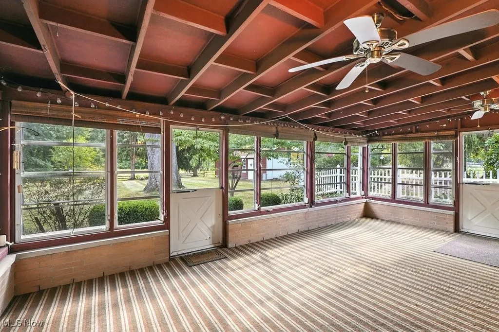 Unfurnished sunroom with ceiling fan