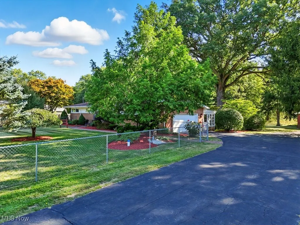 Obstructed view of property featuring asphalt driveway and a garage