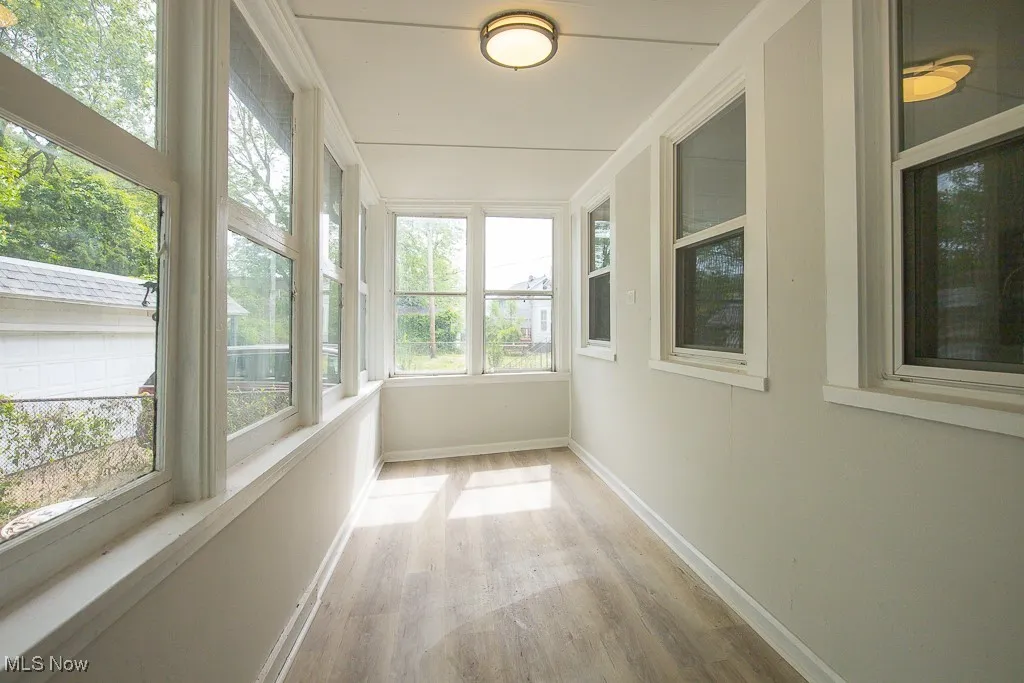 Unfurnished sunroom with plenty of natural light and wood finished floors