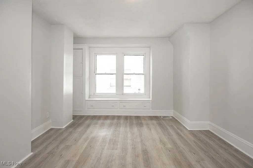 Bonus room with light wood-style flooring and baseboards