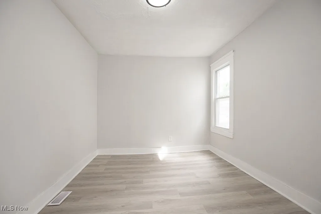 Unfurnished room featuring light wood-type flooring and baseboards