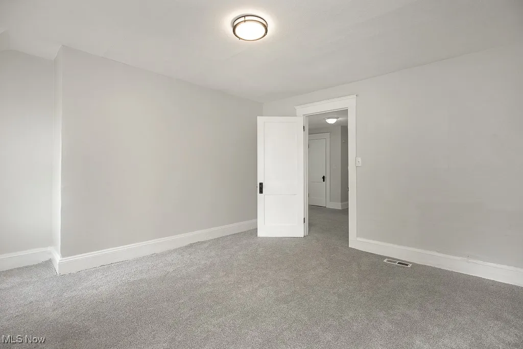 Carpeted empty room featuring baseboards