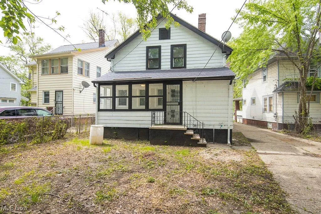 Rear view of property with a chimney and a sunroom