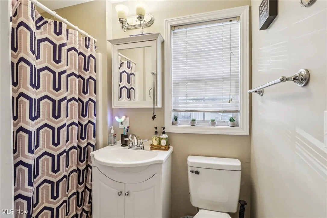 Full bath featuring vanity and curtained shower