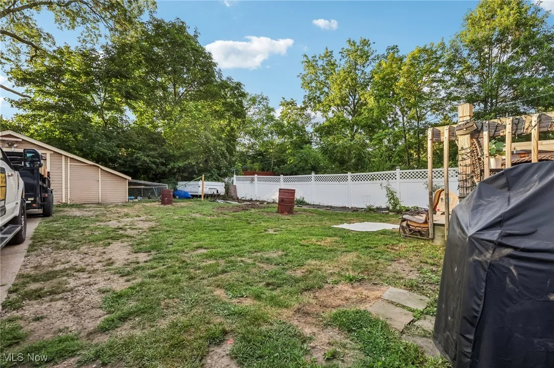Fenced backyard with view of scattered trees
