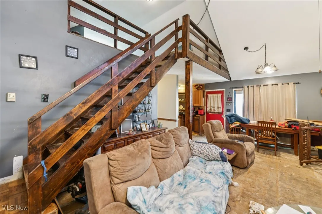 Living room featuring stairs and a high ceiling