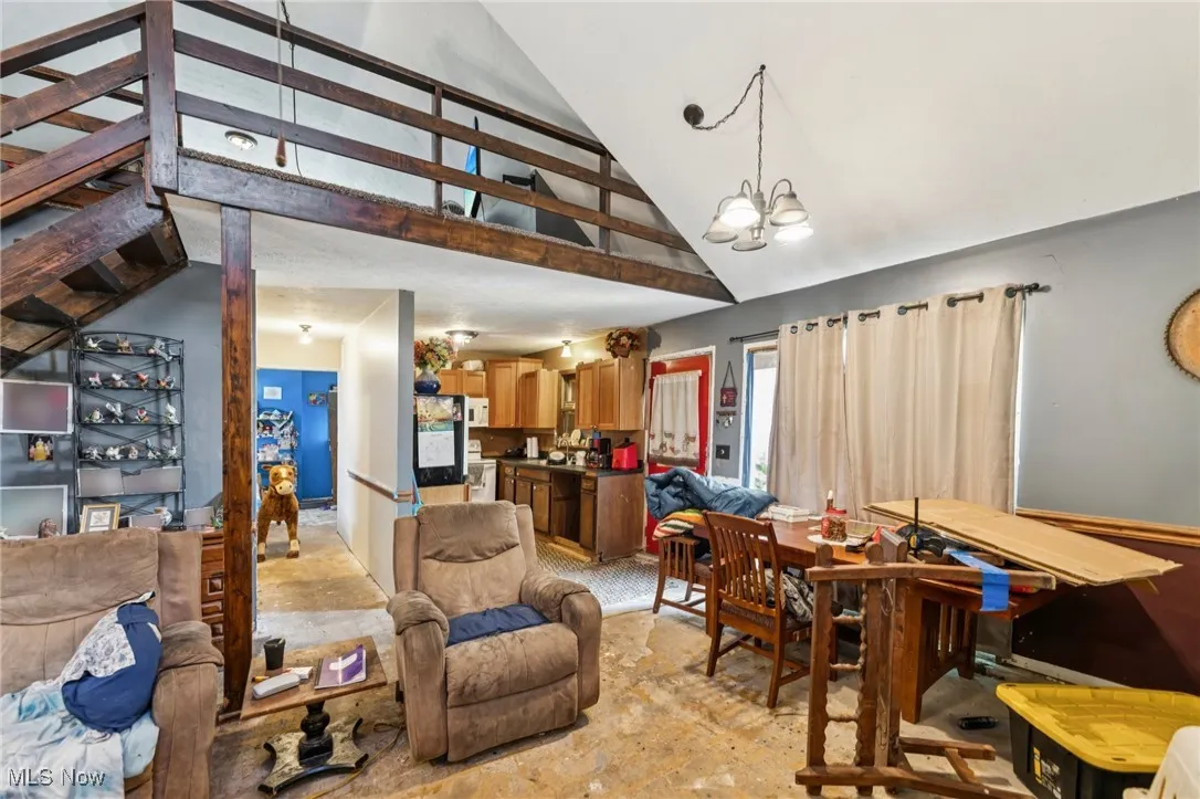 Dining area featuring high vaulted ceiling and a chandelier