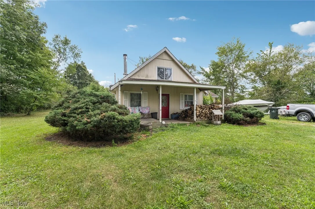 View of front facade featuring covered porch and a front yard