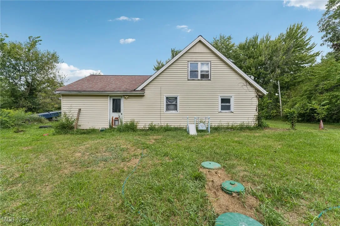 Rear view of property with a lawn