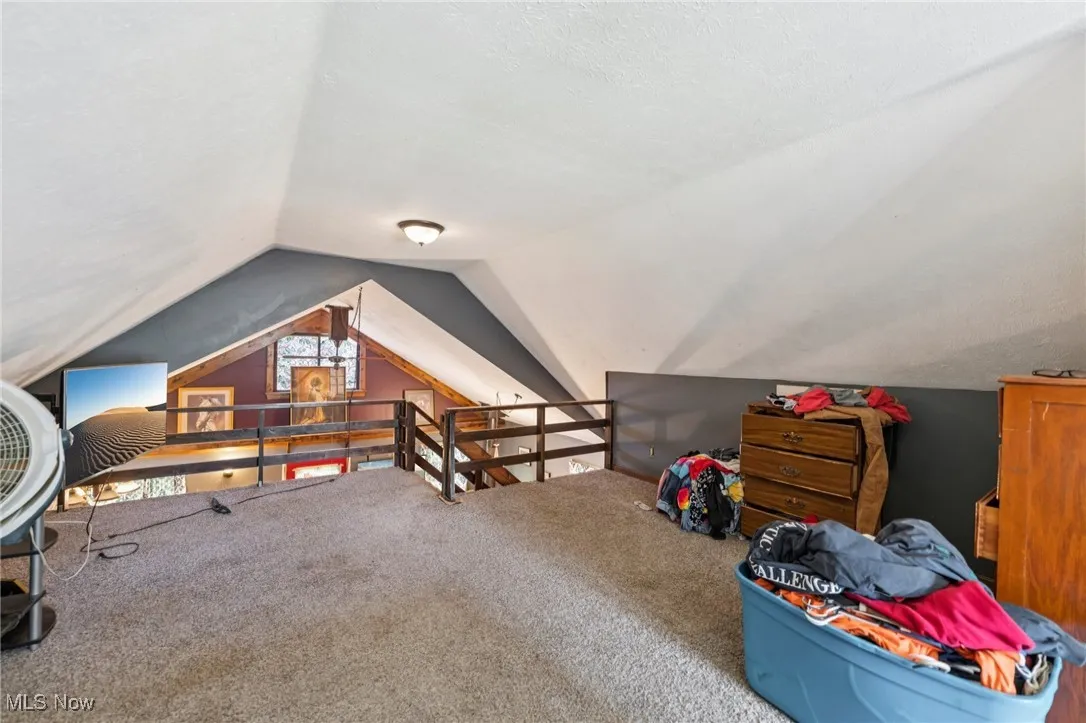 Rec room with carpet flooring and vaulted ceiling